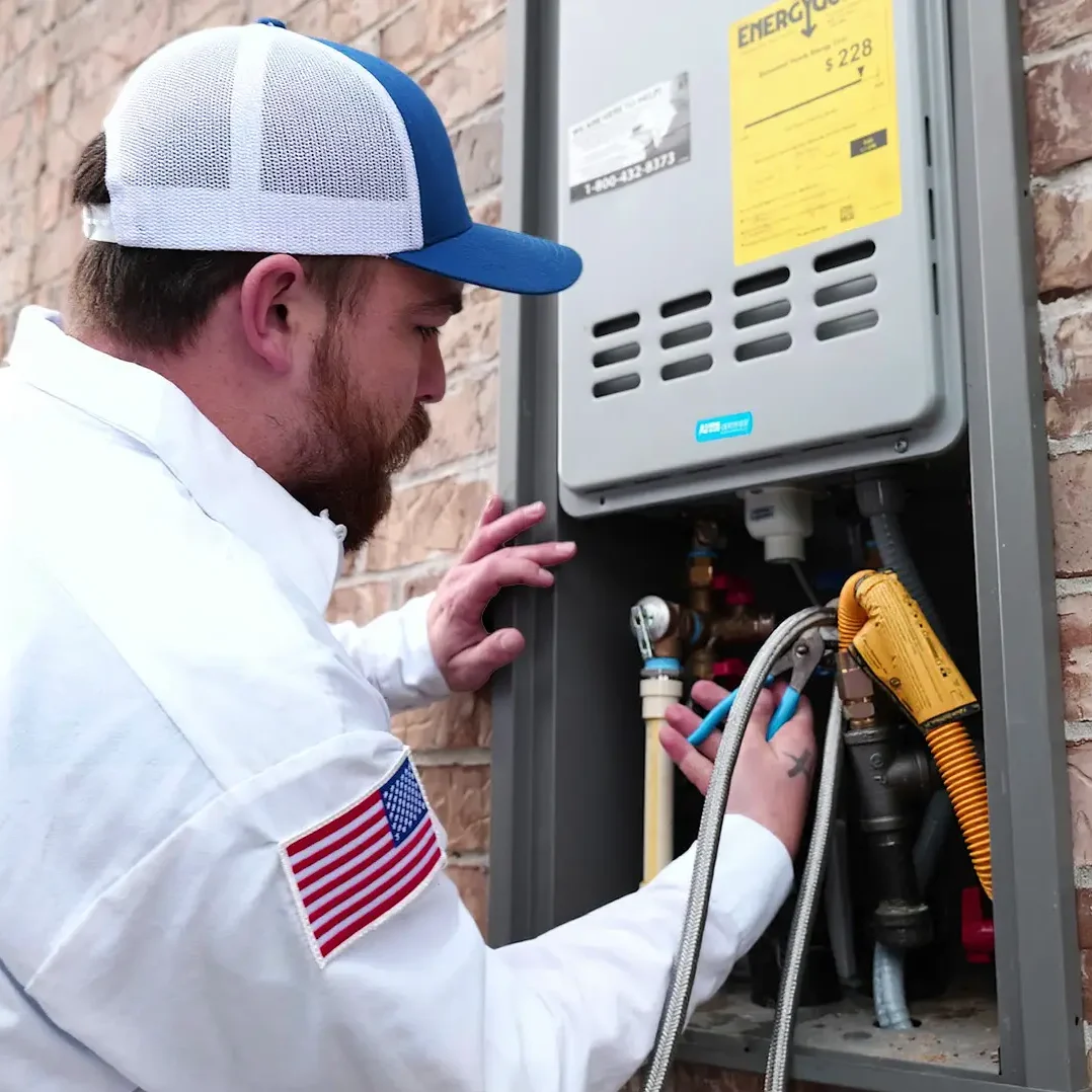 alt text="Square image of technician installing water heater equipment in residential space"
