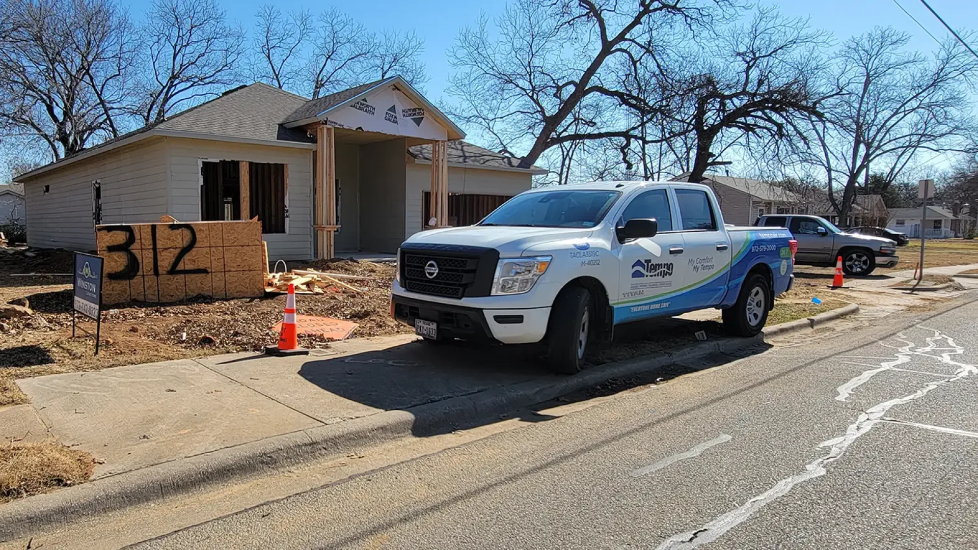 Alt="Photograph of one of Tempo Air's pickup trucks used for HVAC services, in front of a house under new construction."