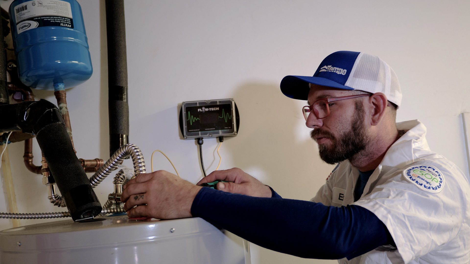 alt="Tempo Air Expert Plumber installing a FlowTech in a Tank Water Heater"