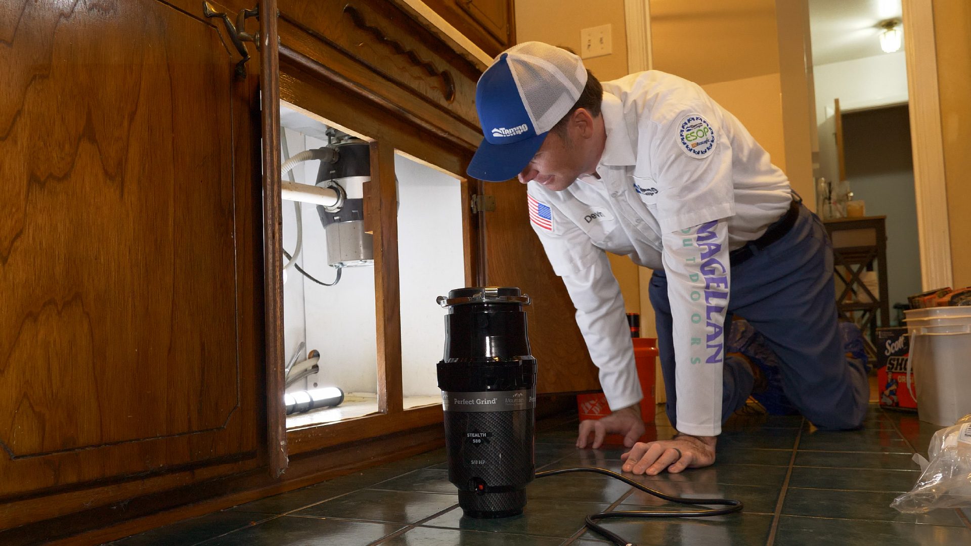 alt="Tempo Air Expert Plumber replacing a old wast disposer, with a new Perfect Grind Stealth 580 Waste Disposer"
